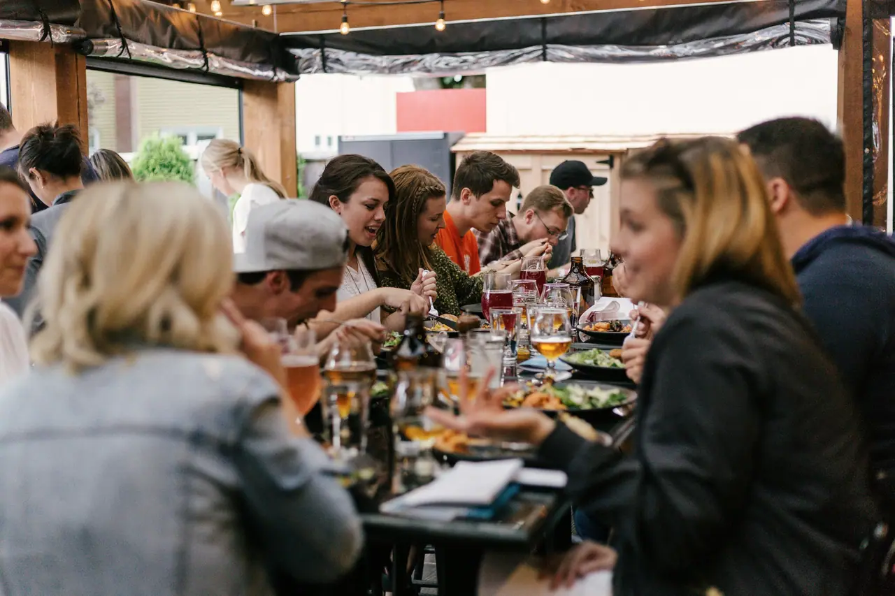 People talking over dinner at a long shared table